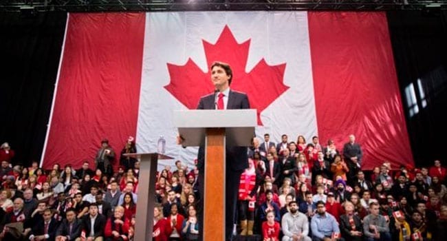 Trudeau in front of Canadian flag