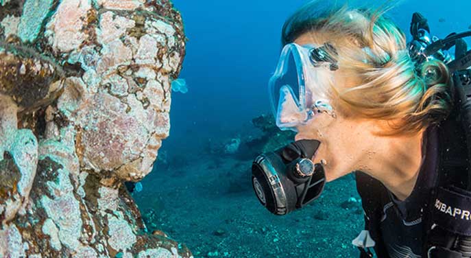 Diver face to face with sculpture